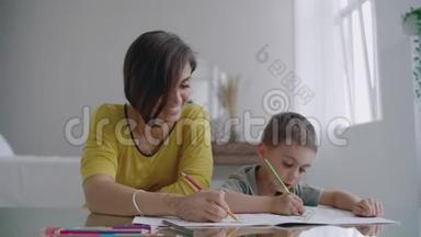 年轻的女人和孩子一起<strong>画画</strong>，用铅笔在平的地方<strong>画画</strong>。